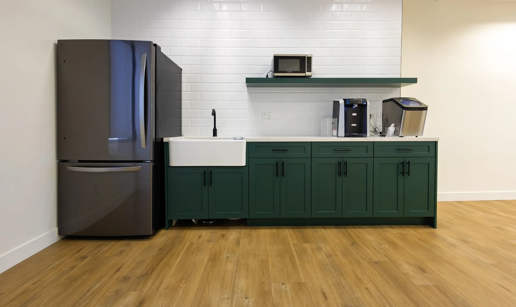Shared kitchenette with green cabinets, refrigerator, and refreshments equipment